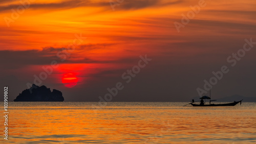 Fishing boats floating in the ocean on the island and sunset background 