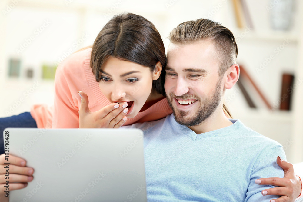 Happy couple working on laptop in a room Happy couple working on laptop in a room