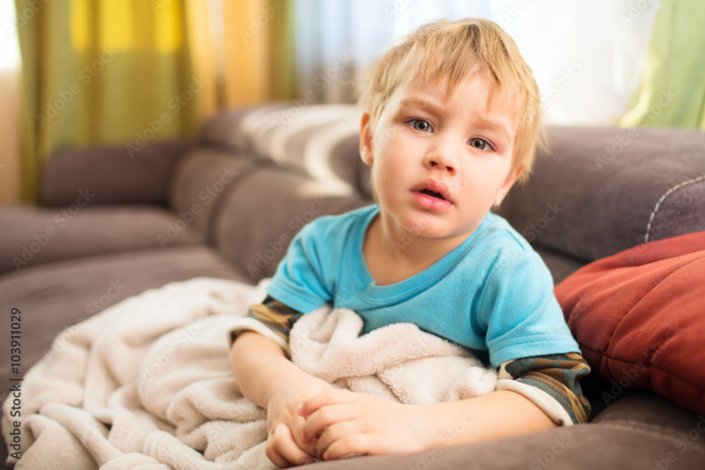 the sad kid sits under a blanket in the room, an illness
the sad kid sits under a blanket in the room, an illness