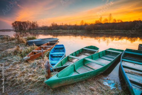Fototapeta Naklejka Na Ścianę i Meble -  River and old wooden rowing fishing boat at beautiful sunrise in