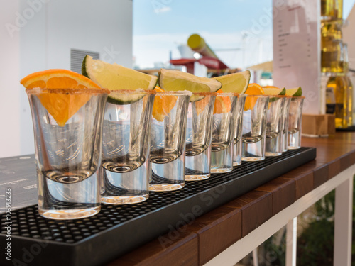 Little Glasses in Line with Orange and Lime Slices Ready to Tequ photo