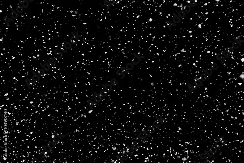 Real falling snow on black background for use as a texture