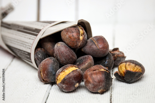 delicious hot toasted chestnuts wrapped on newspaper. photo