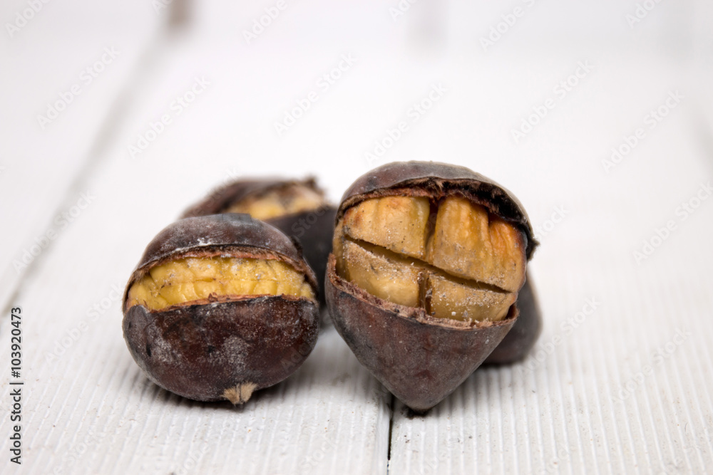 Obraz premium hot toasted chestnuts on white wooden background