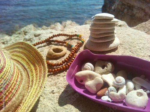 Камушки и шляпа на морском берегу летний отдых
