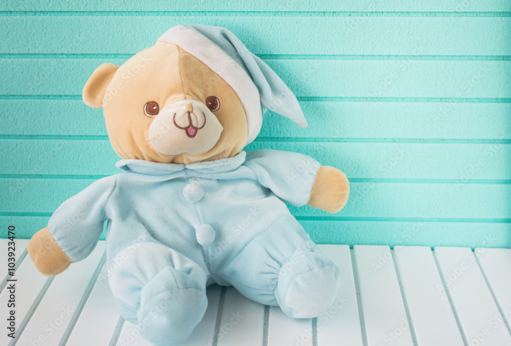Teddy bear in pajama on white wooden base and light green background Stock  Photo