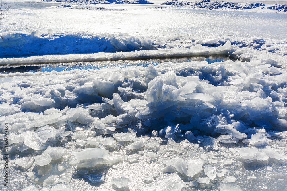 broken ice near hole in frozen lake