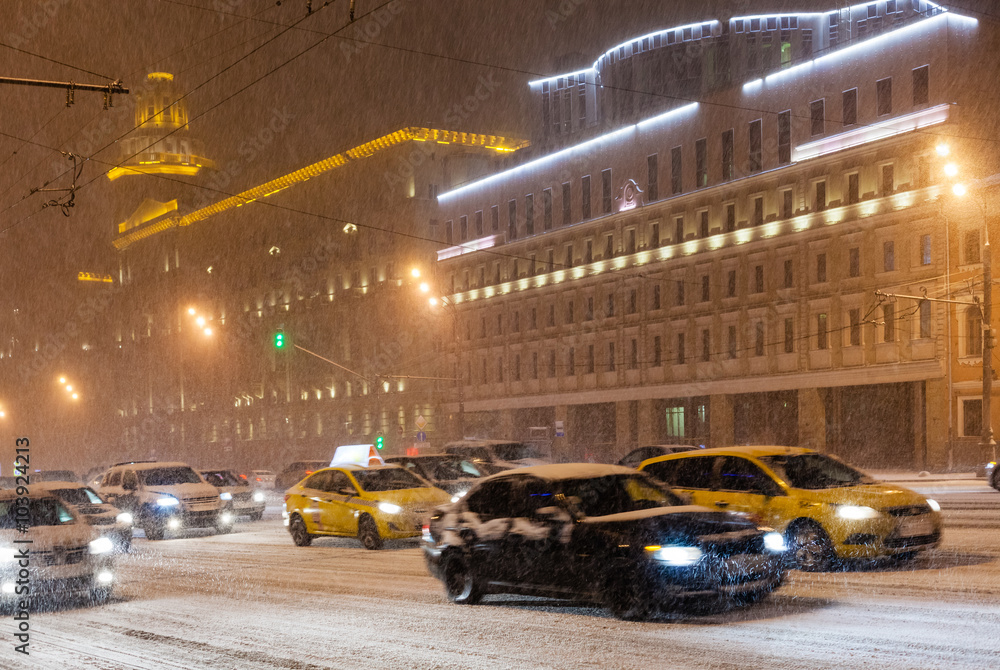 street traffic under snow in night city