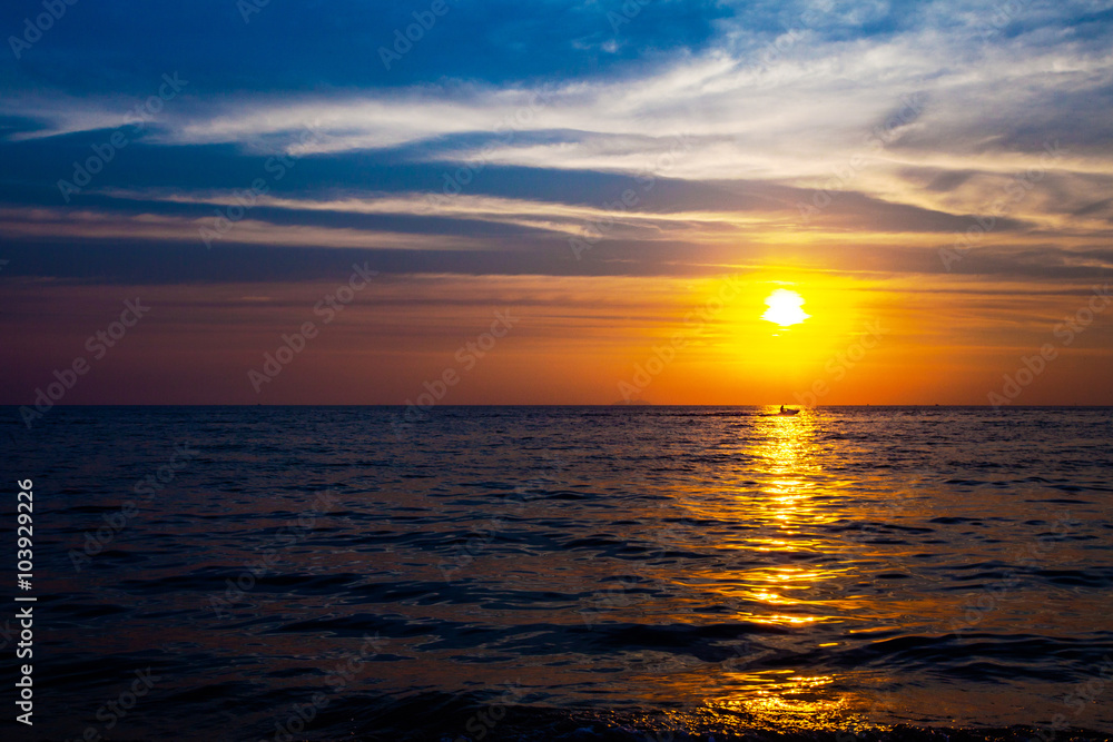 Fototapeta premium Drifting boat in the ocean on a sunset 