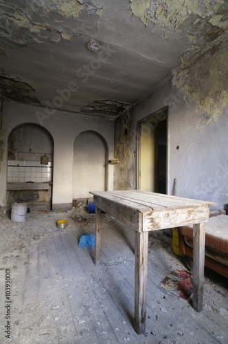 Old abandoned room with a wooden table © marcobarone
