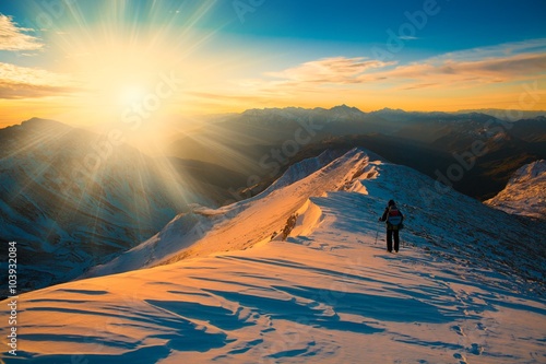 A man in mountain sunset winter