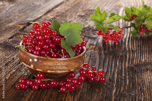 Red currant on wooden background.