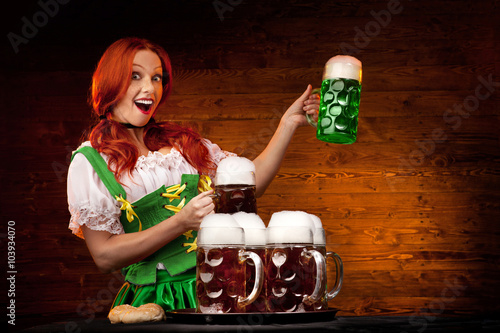Bavarian Woman with Five Brown Beer Glasses and one Green Beer G photo