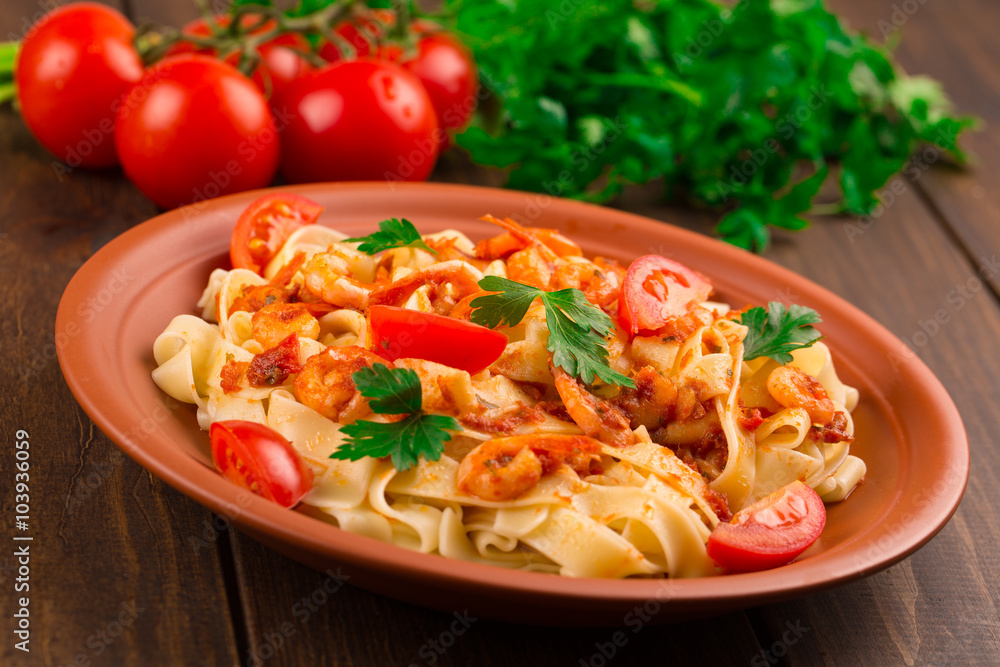 Fettuccine pasta with shrimp tomatoes and herbs. wooden background Fettuccine pasta with shrimp tomatoes and herbs. wooden background