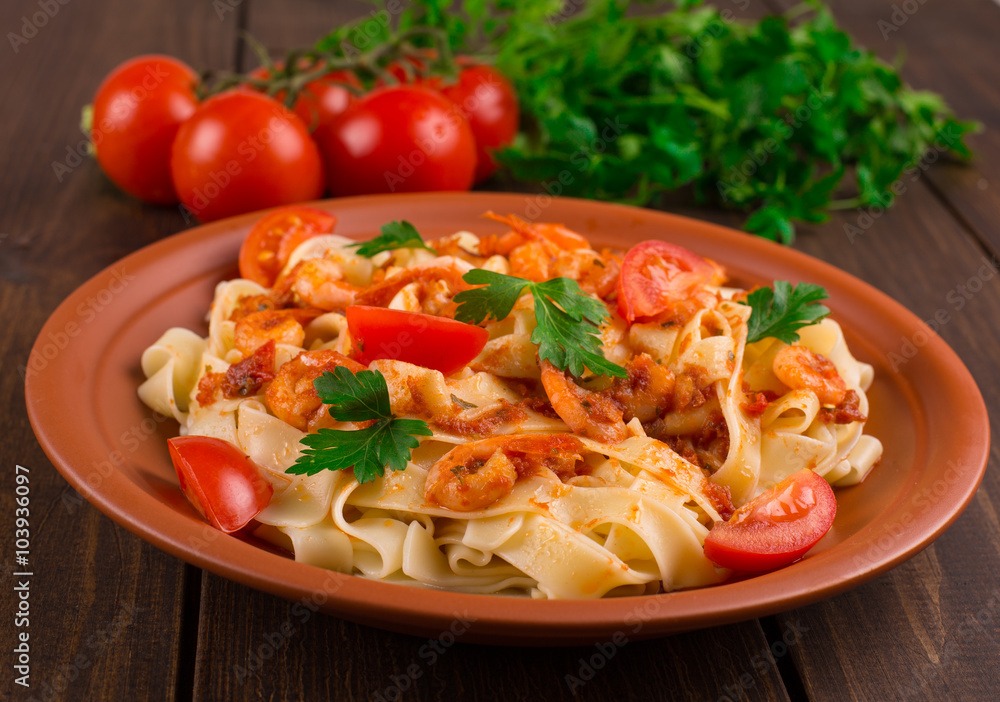 Fettuccine pasta with shrimp tomatoes and herbs. wooden background Fettuccine pasta with shrimp tomatoes and herbs. wooden background