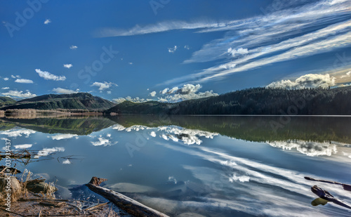 Blue Skies, Green Hills, and White Clouds Reflect in Still Waters of Alder Lake on the Way to Mt. Rainier
