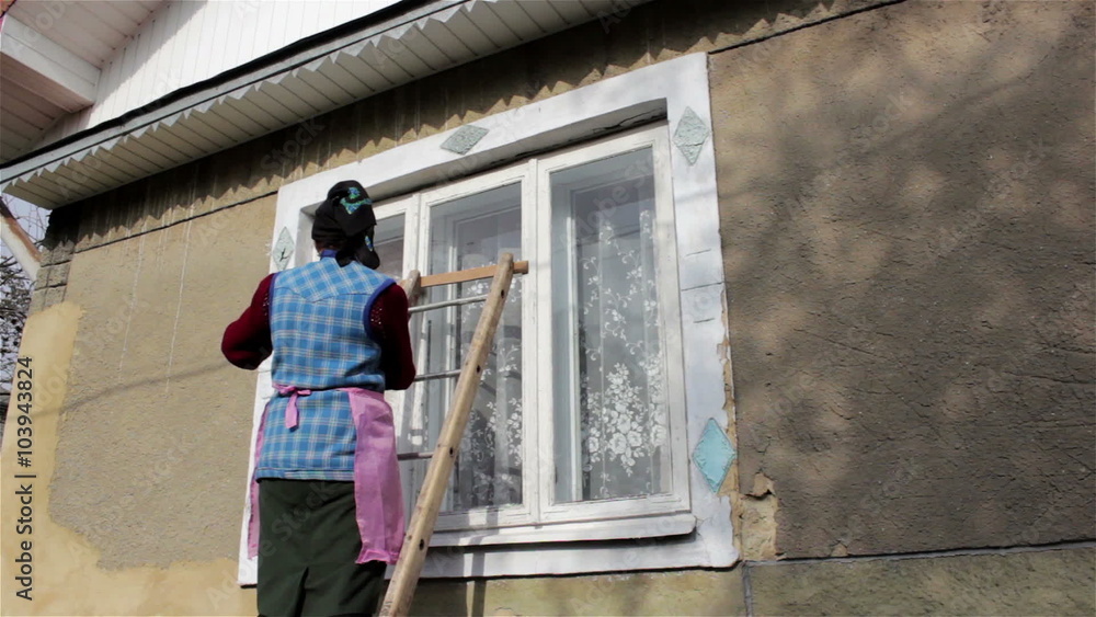 woman on a ladder/woman climbs a ladder to wash the window woman on a ladder/woman climbs a ladder to wash the window