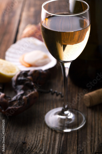 Glass of wine and scallops on a wooden