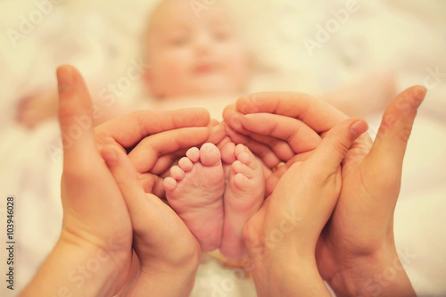 small children's feet in the hands of parents