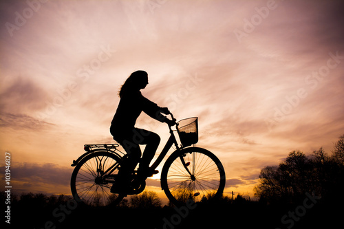 Silhouette of the girl on bicycle - beautiful sunset