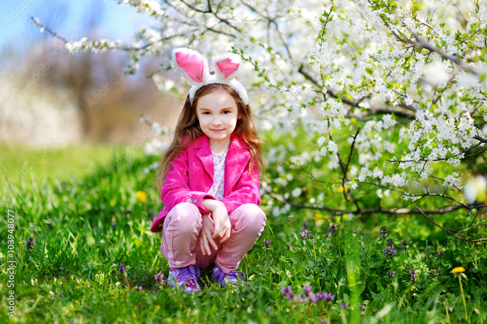 Adorable little girl in blooming cherry garden Adorable little girl in blooming cherry garden