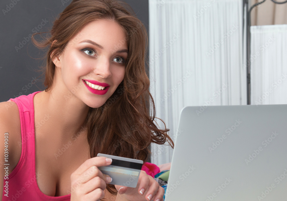 Happy woman lying bed surrounded by her clothes Happy woman lying bed surrounded by her clothes