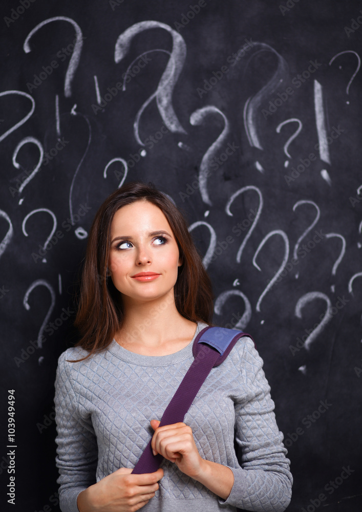 Young girl with question mark on a gray background Young girl with question mark on a gray background