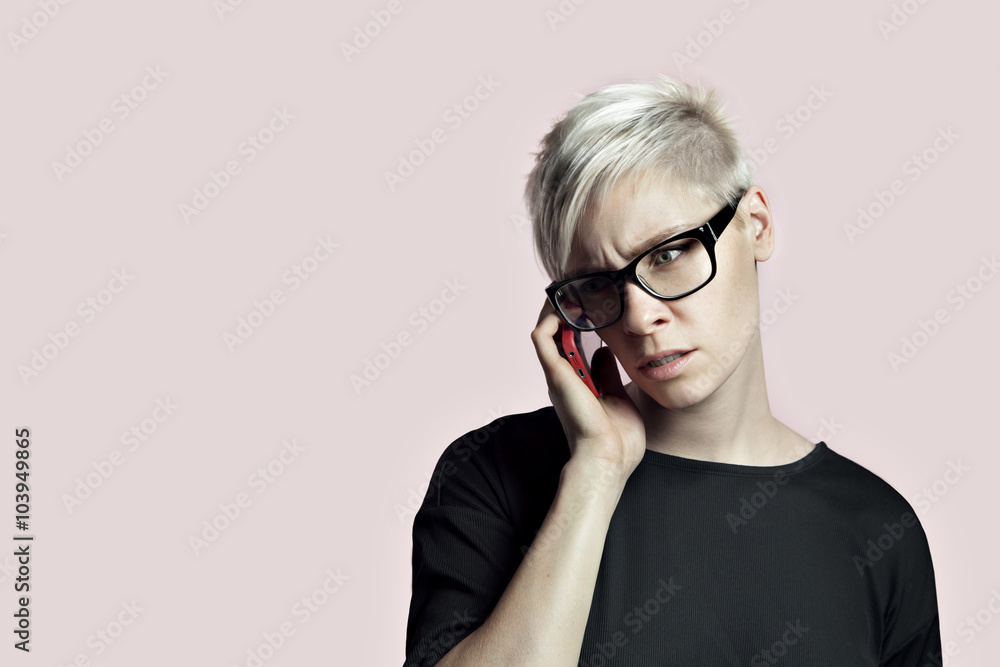 Portrait of blonde woman with smartphone and glasses, short hair pink background Portrait of blonde woman with smartphone and glasses, short hair pink background