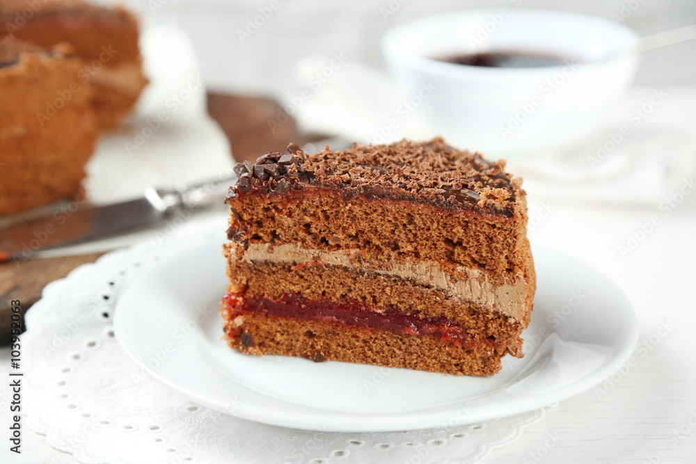 Sliced chocolate cake on wooden table, on light background Sliced chocolate cake on wooden table, on light background