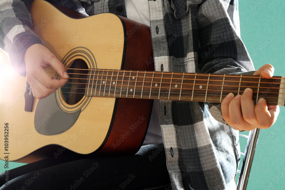 Fototapeta premium Musician plays guitar on blue background, close up