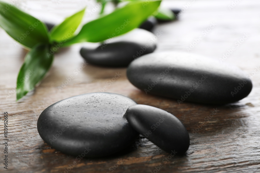 Fototapeta premium Spa stones and bamboo branch on wooden background