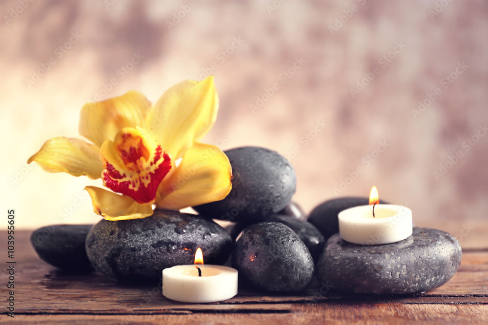 Spa still life with stones, flower and candlelight on blurred pastel background Spa still life with stones, flower and candlelight on blurred pastel background
