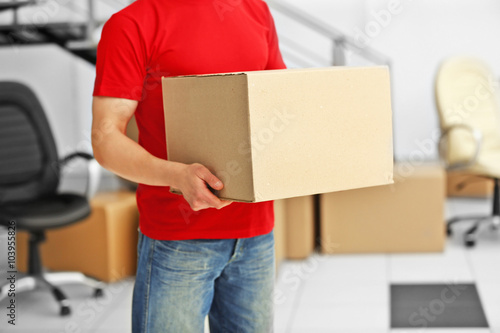 Man holding carton box in the room, close up © Africa Studio