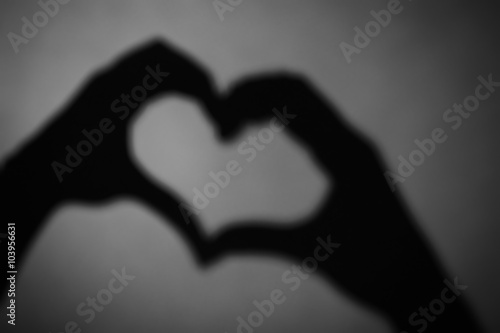 Hand shaped heart on dark background