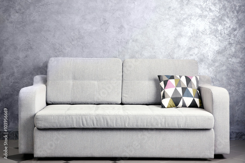 Comfortable sofa against grey wall in the room, close up © Africa Studio