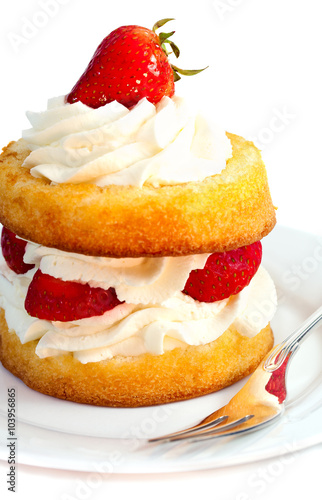 Photo Strawberry shortcake serving on a white plate with silver fork against white background