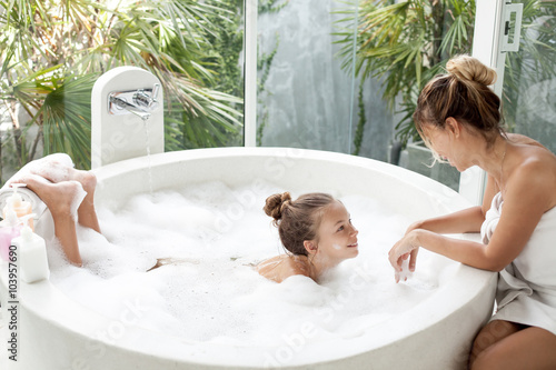 Картината върху платно Mother with a child washing in bath