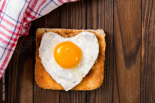 heart shaped cooked egg on a slice of toast