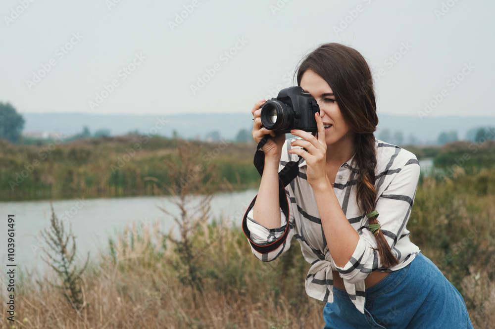 pretty playful country lady posing with camera against pond