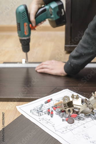 Wallpaper Mural Assembling furniture from chipboard, using a cordless screwdriver Torontodigital.ca