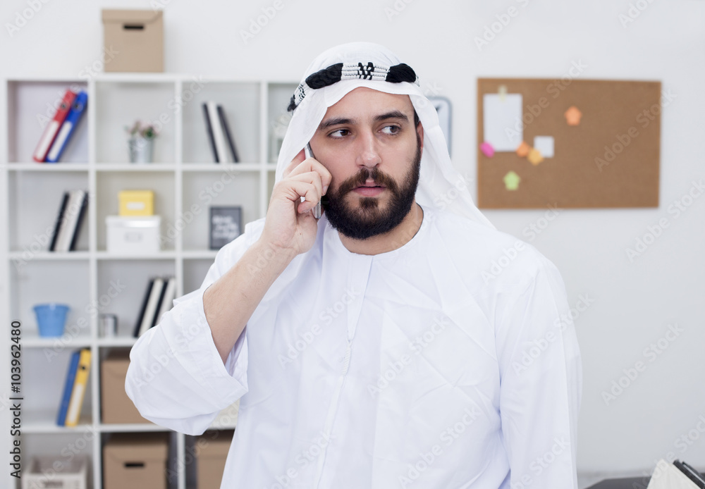 Young Arabic business man Talking on phone in his office