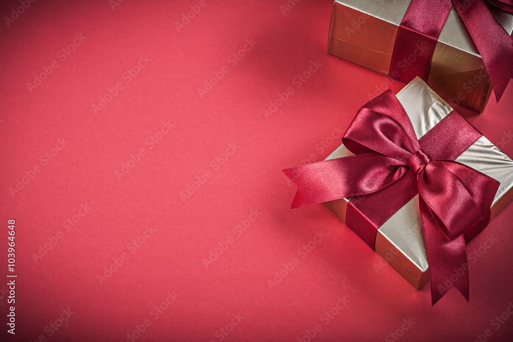 Packed present containers with bow on red background holidays co