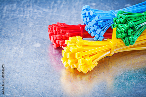 Multicolored plastic tying cables on metallic background constru photo