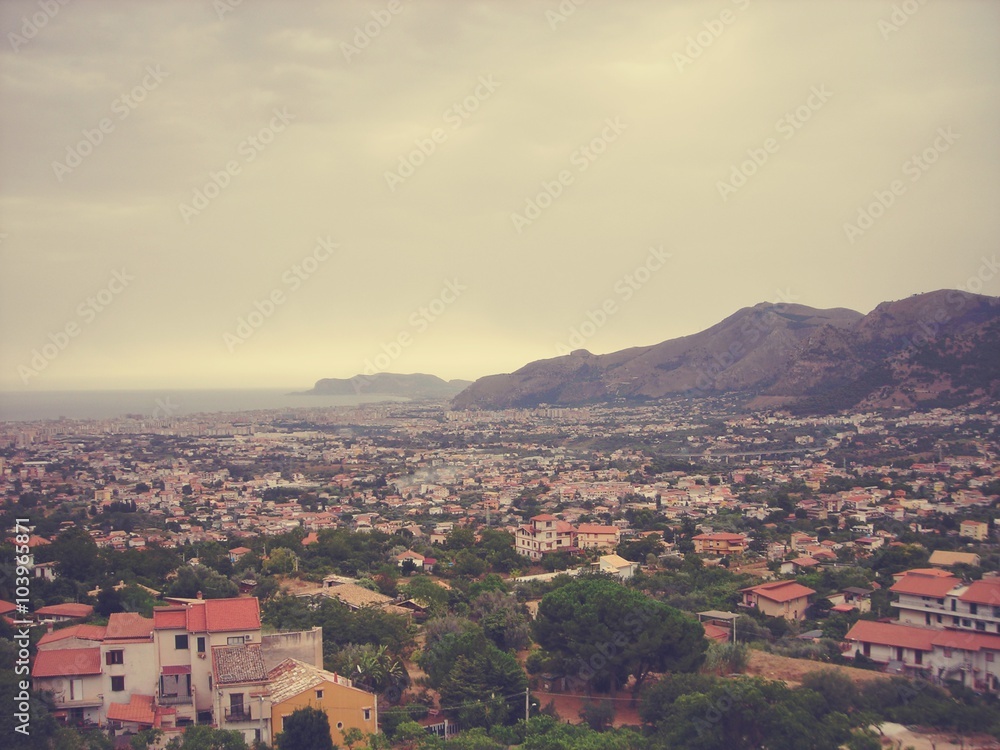 Panoramic view on the city of Palermo from Monreale hill, on a cloudy summer day. Image filtered in faded, retro, Instagram style; nostalgic concept of summer travel.