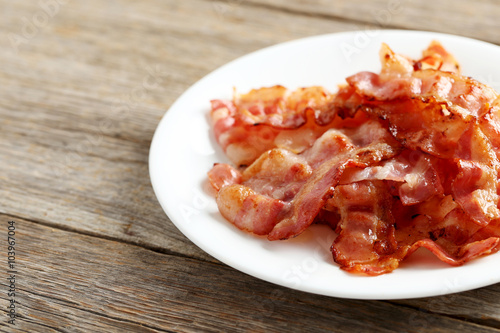 Crispy strips of bacon on a grey wooden background