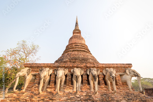 Photography An ancient laterite/sandstone pagoda in Sukhothai's UNESCO world heritage historical park with elephant sculptures all around the four sides