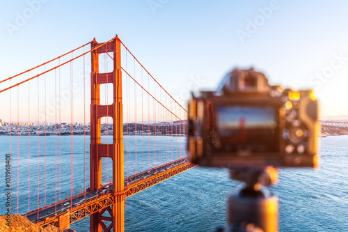 camera and gold gate bridge in blue sky at dawn