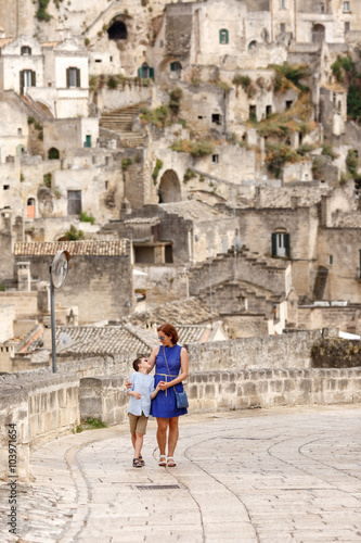 Young mother and her little son walking outdoors in city