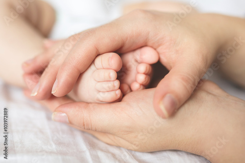 Baby feet in hands of mother