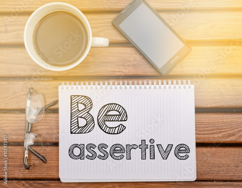 Canvas Print Notebook on table with text about soft competence: Be assertive